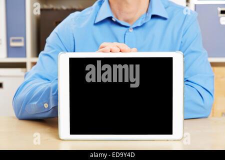 Hand holding tablet PC with empty black screen on office desk Stock Photo