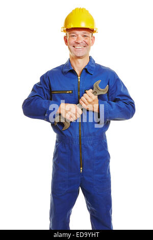 Smiling construction worker in boiler suit with safety helmet and jaw wrench Stock Photo