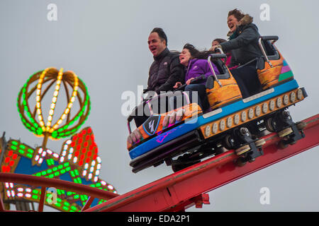 London, UK. 01st Jan, 2015. Winter Wonderland in Hyde Park contuinues to draw large crowds from all segments of London society - families and adults of all ages seem to be seeking the last drops of festive spirit by partaking in the fun fair activities and side show as well as by drinking and eating high calorie foods. Smiles are in fairly short supply apart from from kids getting ballons and people on the roller coaster. Credit:  Guy Bell/Alamy Live News Stock Photo