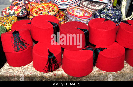 Called a fez (fes), bright red felt hats with black tassels are sold as souvenirs to tourists at an outdoor market in Istanbul, Turkey. Stock Photo