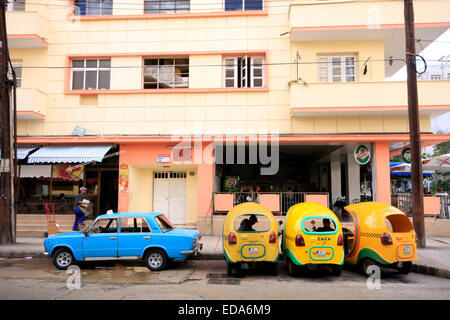 Old and new in Havana - A Russian made Lada parked next to Coco Taxis in a street in the Cuban capital Stock Photo