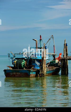 Detailed view of a working Asian fishing boat moored alongside an old wooden pier on Penang Island. Stock Photo