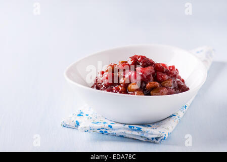 Pear cranberry relish in a white bowl over light blue background with copy space Stock Photo