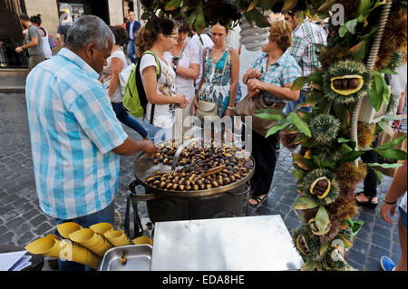 Vendor selling roasted chestnuts to tourists on the street of Rome, Italy. Stock Photo