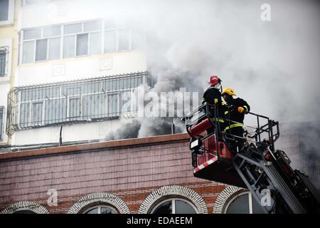 (150104) -- HARBIN, Jan. 4, 2015 (Xinhua) -- Smokes rise from a burnt warehouse at the Beifangnanxun ceramics market in Daowai District, Harbin, capital of northeast China's Heilongjiang Province, Jan. 4, 2014. The warehouse blaze in Harbin City that killed 5 firefighters still hasn't been completely extinguished, local firefighters said on Sunday. As of 10:40 a.m. Sunday, a residential building next to the warehouse was still smoldering. Rescuers said that the source of the fire has been hard to determine due to the building's complicated structure, and the building is at risk of collapsing. Stock Photo