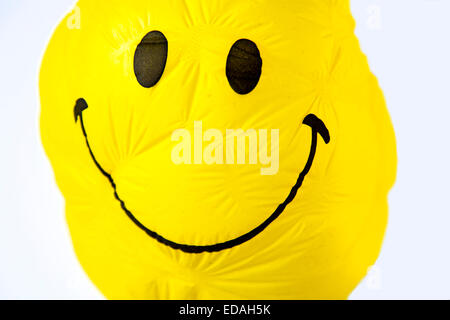 old Balloon, yellow, shriveled with friendly smiley face, sunken ...