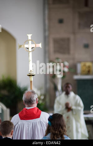 Priest carrying cross for catholic mass Stock Photo