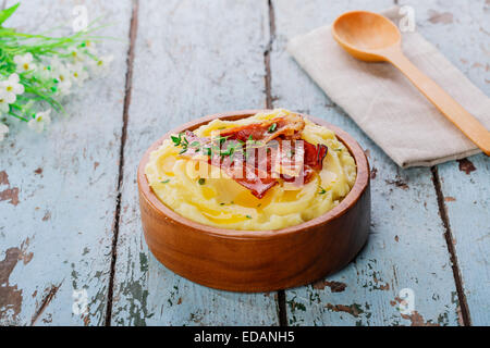 mashed potatoes with bacon in a wooden bowl Stock Photo