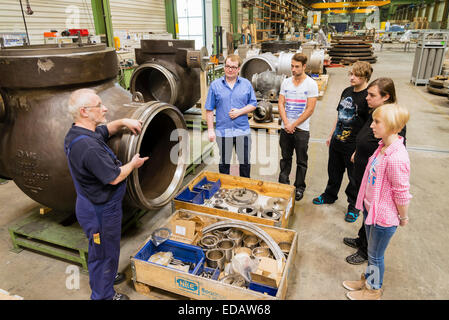 A trainee teacher, left, shows a production hall to new apprentices at the start of their apprenticeship. Stock Photo