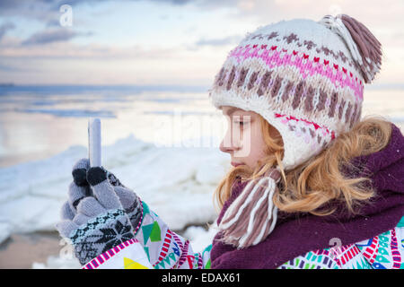 Little blond Caucasian girl taking pictures on her smartphone camera Stock Photo