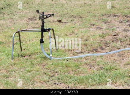 Lawn sprinkler head dispersing water on grass in city park. Grass sprinkler  spraying water on lawn close up Stock Photo - Alamy