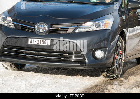 Snow chain / chains on front wheel / wheels of a car also fitted with winter tyres / tires. (75) Stock Photo