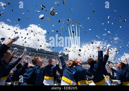 Newly commissioned second lieutenants throw their hats in the air during the commencement ceremony as the Thunderbirds fly over Falcon Stadium at the United States Air Force Academy May 28, 2014 in Colorado Springs, CO. Stock Photo