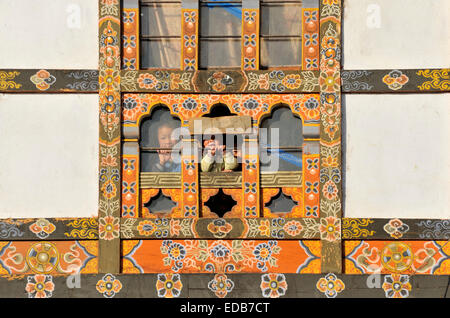 Children looking through the window, Jakar, Bumthang, Bhutan Stock Photo
