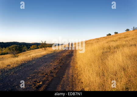 A couple walks down a scenic country road, Southeastern Arizona Stock Photo