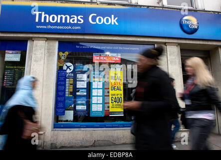 People pass a branch of Thomas Cook travel agency in Islington, London. Stock Photo