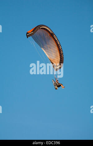 Powered paragliding at Bournemouth, Dorset UK  in July motorised paraglider against blue sky - paraglider Stock Photo
