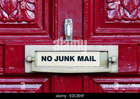 No Junk Mail sign on a bright red front door and associated door furniture. Stock Photo