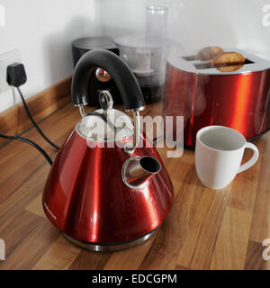 Kettle boiling with steam and toaster cooking toast behind in kitchen plugged in electrical appliances Stock Photo