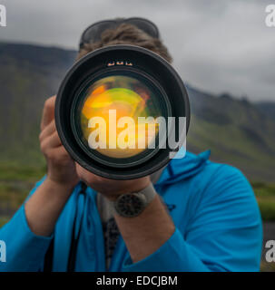Photographer using a long lens to photograph near Seljalandsfoss Waterfall, South Coast, Iceland Stock Photo