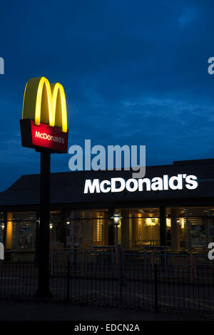 London, UK - November 16, 2014: McDonalds logo on blue sky background. McDonald's Corporation is the world's largest chain, over Stock Photo