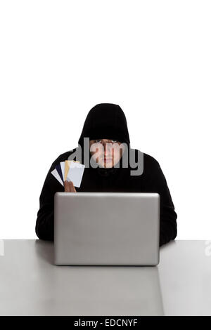 Hacker in black dress with credit cards on a silver laptop computer isolated on white background Stock Photo