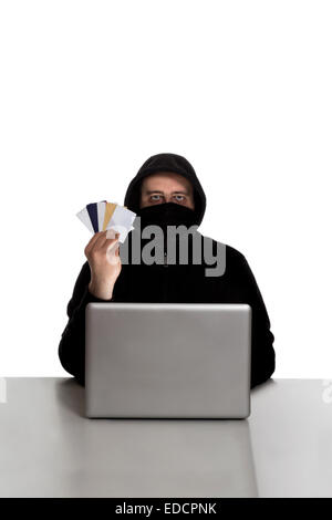 Hacker in black dress with credit cards on a silver laptop computer isolated on white background Stock Photo