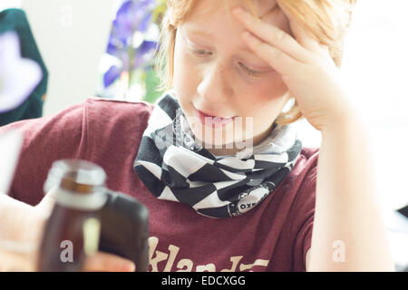 Boy playing iphone in refectory restaurant Stock Photo