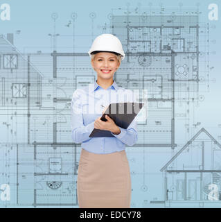 smiling businesswoman in helmet with clipboard Stock Photo