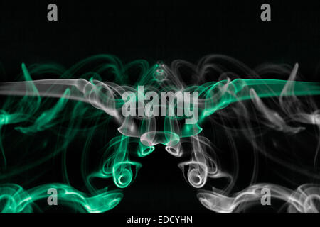 Abstract smoke pattern.  Green and white smoke on a black background.  Flipped and rotated to make a symmetrical shape. Stock Photo