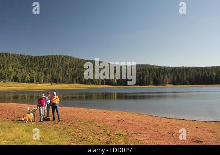 Three friends and dogs at Gregorio Lake in  Jemez Mountains of New Mexico - USA Stock Photo