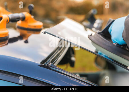 A technician for Autoglass fitting a new windscreen Stock Photo