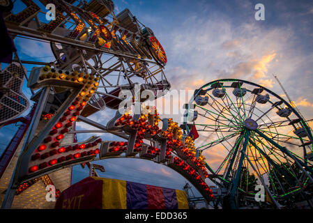 Amusement rides at a county fair at sunset. Stock Photo