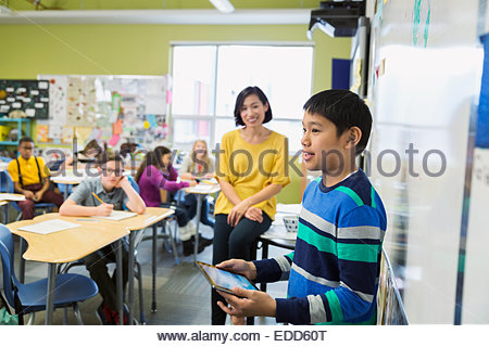 Student with digital tablet in front of classmates Student with digital tablet in front of classmates