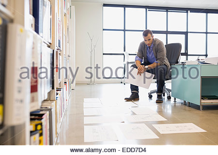 Architect looking at plans on floor