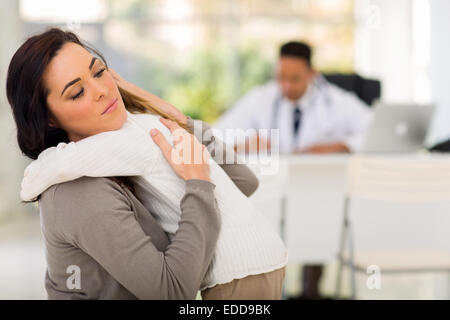caring mother comforting her ill daughter in doctor's office Stock Photo