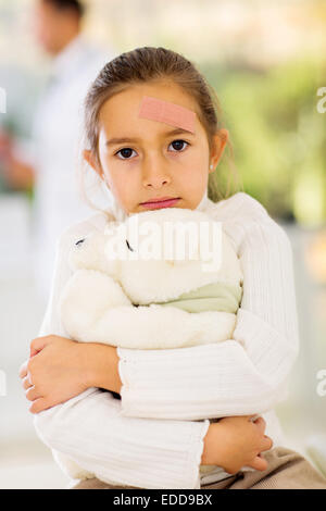 injured girl with band-aid on her forehead in hospital Stock Photo