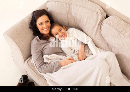 beautiful young girl and her cute mother lying on the couch Stock Photo