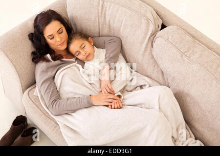 cute mother and her little girl sleeping on the couch Stock Photo