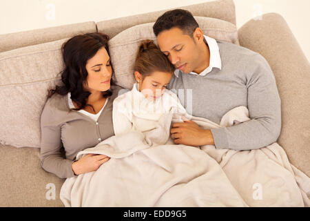 above view of family sleeping together on the couch at home Stock Photo