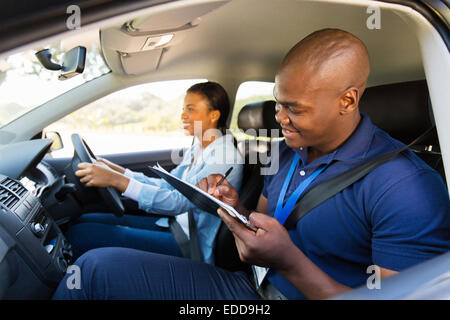 African girl taking driving test with professional instructor Stock Photo