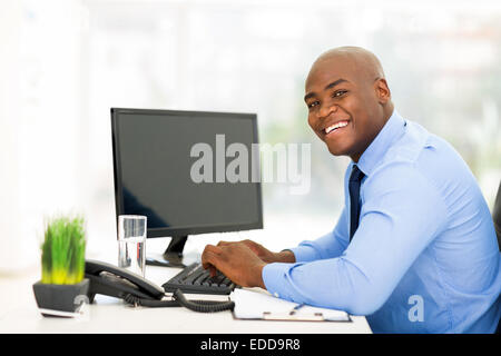 cheerful young black businessman using computer in office Stock Photo
