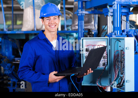portrait of happy industrial engineer with laptop computer Stock Photo