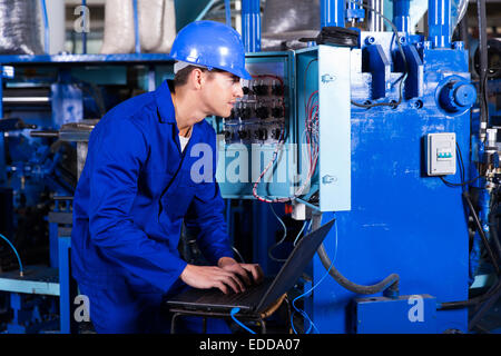 professional young electrician analyzing data on his laptop Stock Photo