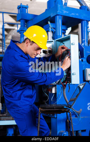 industrial technician repairing modern computerized machine in factory Stock Photo