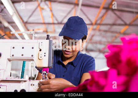 pretty young African worker sewing in clothing factory Stock Photo