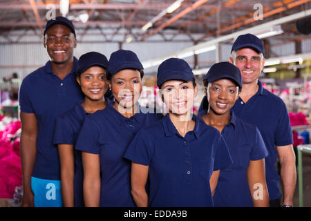 group of happy clothing factory workers inside production area Stock Photo
