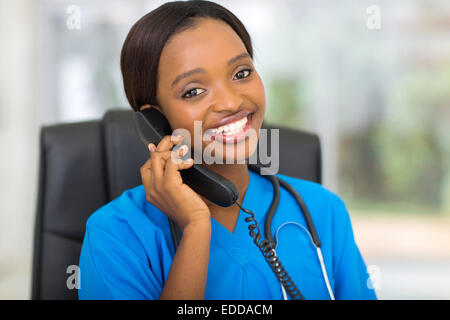 attractive African medical doctor talking on telephone Stock Photo