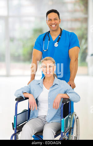 handsome medical male nurse taking care of senior patient in wheelchair Stock Photo
