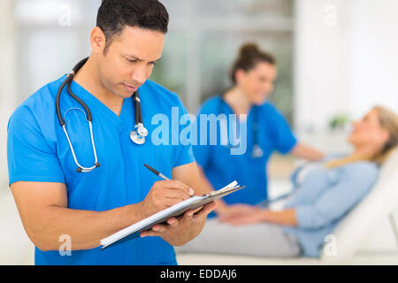 professional middle aged doctor writing medical report Stock Photo